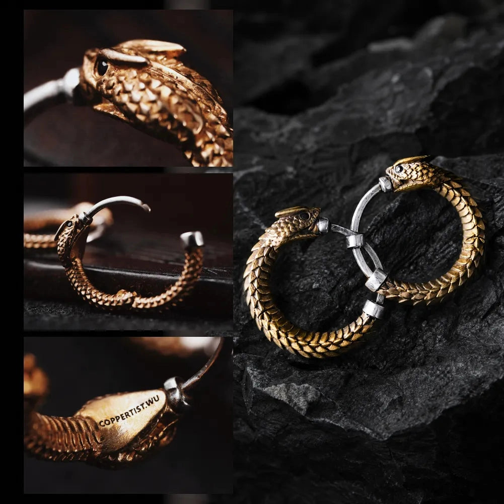 Une paire de boucles d’oreilles Ouroboros en forme d’anneau exposées sur des rochers sombres