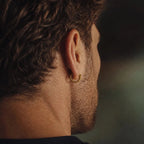 Back view of a man wearing Ouroboros hoop earrings