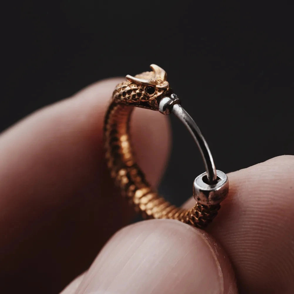Single Ouroboros hoop earring held in hand